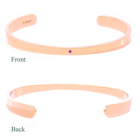 Truelements Jewelry pink gold 316L surgical stainless steel bangle featuring a small natural ruby accent