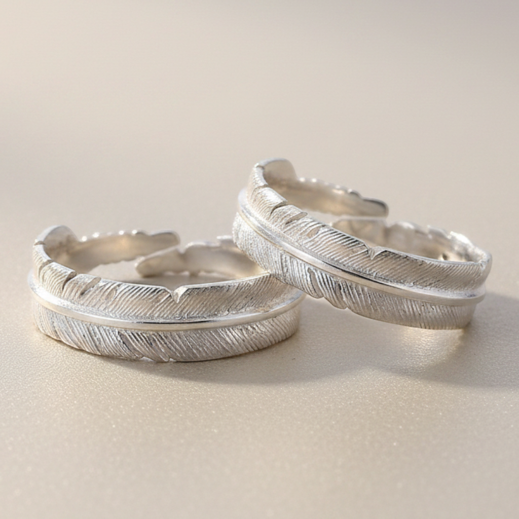 Truelements Jewelry sterling silver feather couple rings with adjustable open design on a neutral background