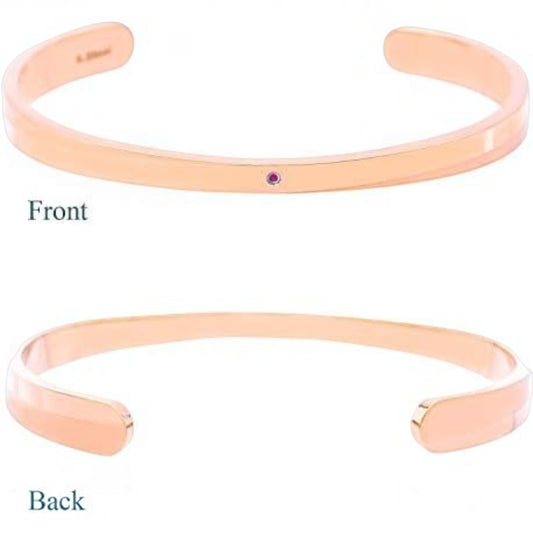 Truelements Jewelry pink gold surgical stainless steel bangle featuring a small natural ruby accent