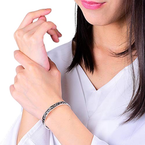 Truelements Jewelry sterling silver arabesque cuff bangle with intricate oxidized filigree worn on a woman's wrist