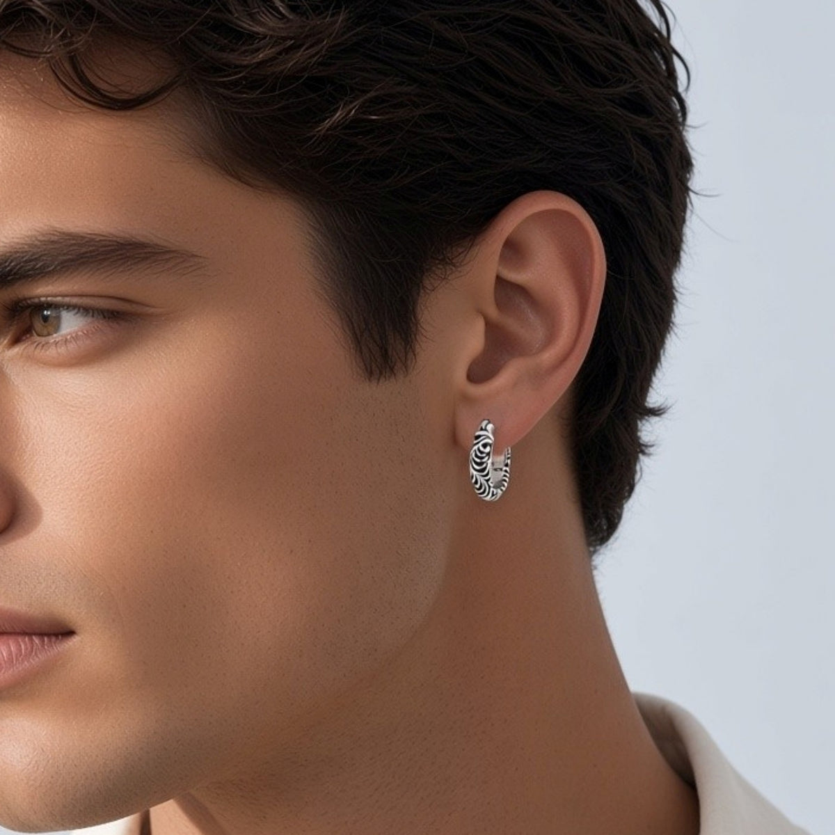 Truelements Jewelry men's 15mm sterling silver hoop earring featuring intricate arabesque engravings worn on ear