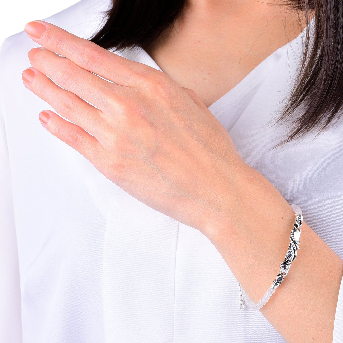 Truelements Jewelry sterling silver arabesque bracelet with 4mm rainbow moonstone beads worn on a woman's wrist