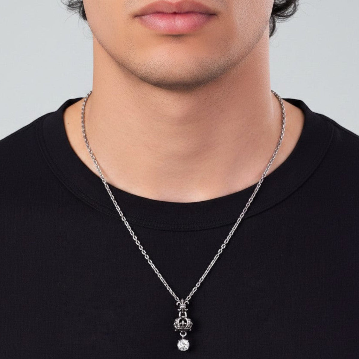 Truelements Jewelry sterling silver crown and cross pendant with a clear cubic zirconia stone on a silver chain.