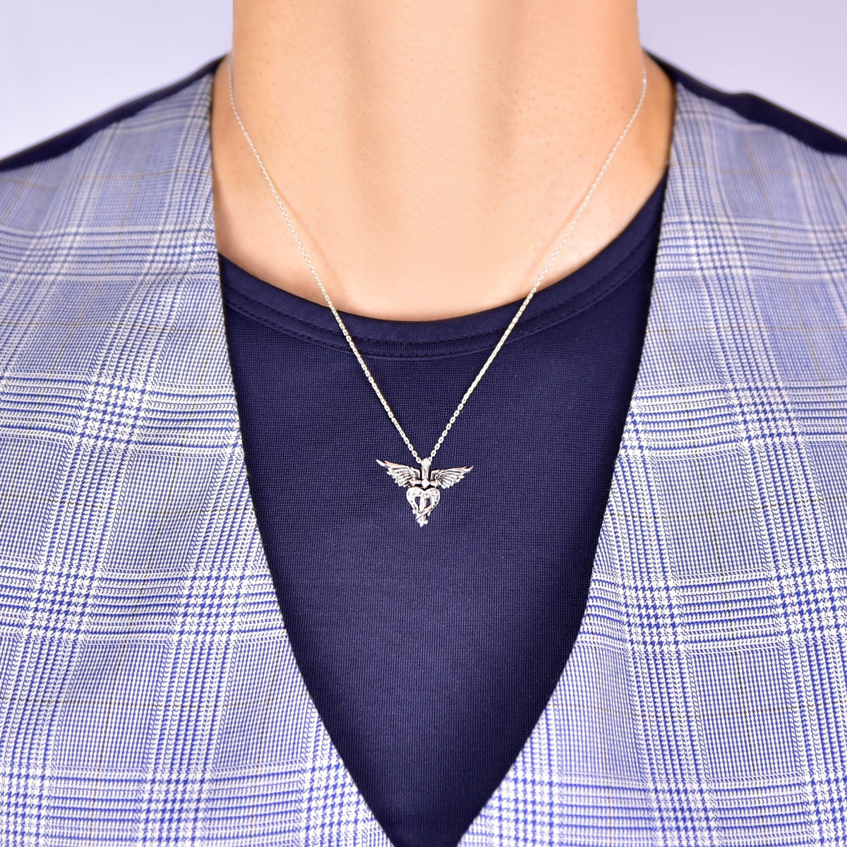 Truelements Jewelry sterling silver pendant featuring a feathered cross and heart design with cubic zirconia accents