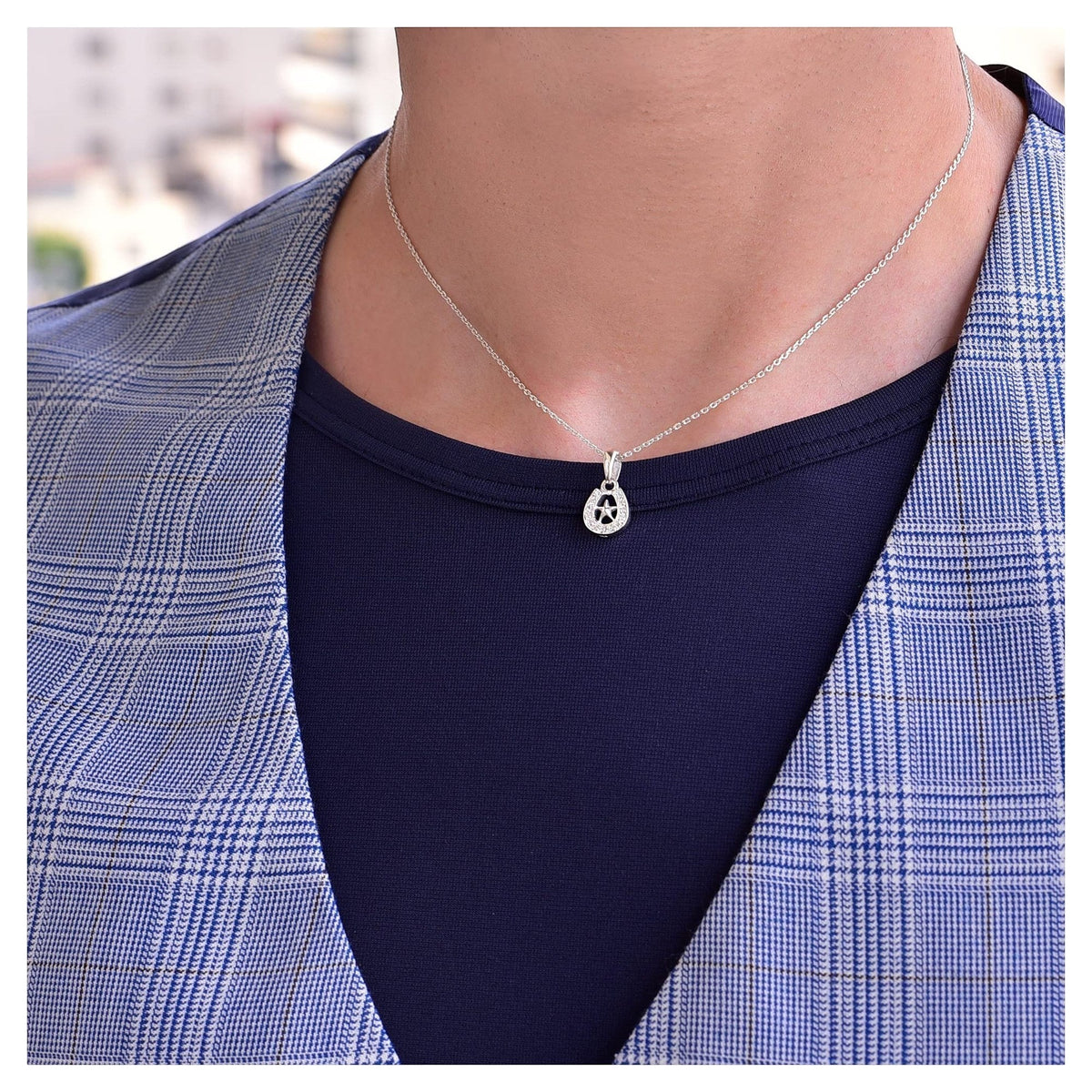 Truelements Jewelry sterling silver horseshoe and star pendant necklace with clear zirconia worn by a man