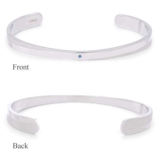 Truelements Jewelry men's 316L surgical stainless steel bangle featuring a small natural light blue sapphire.