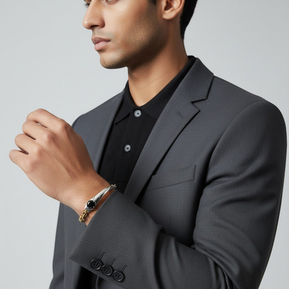 Truelements Jewelry two-tone bracelet in sterling silver and brass with a black zirconia stone on a man in a suit